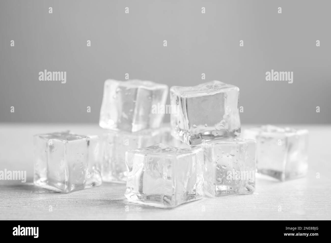 Ice cubes with water drops on white wooden table, closeup Stock Photo