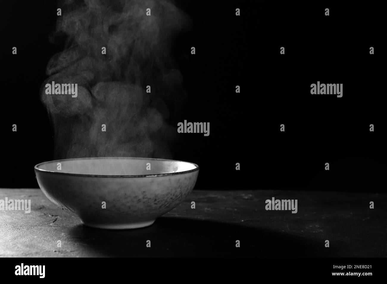Bowl with white steam on black slate table. Space for text Stock Photo ...