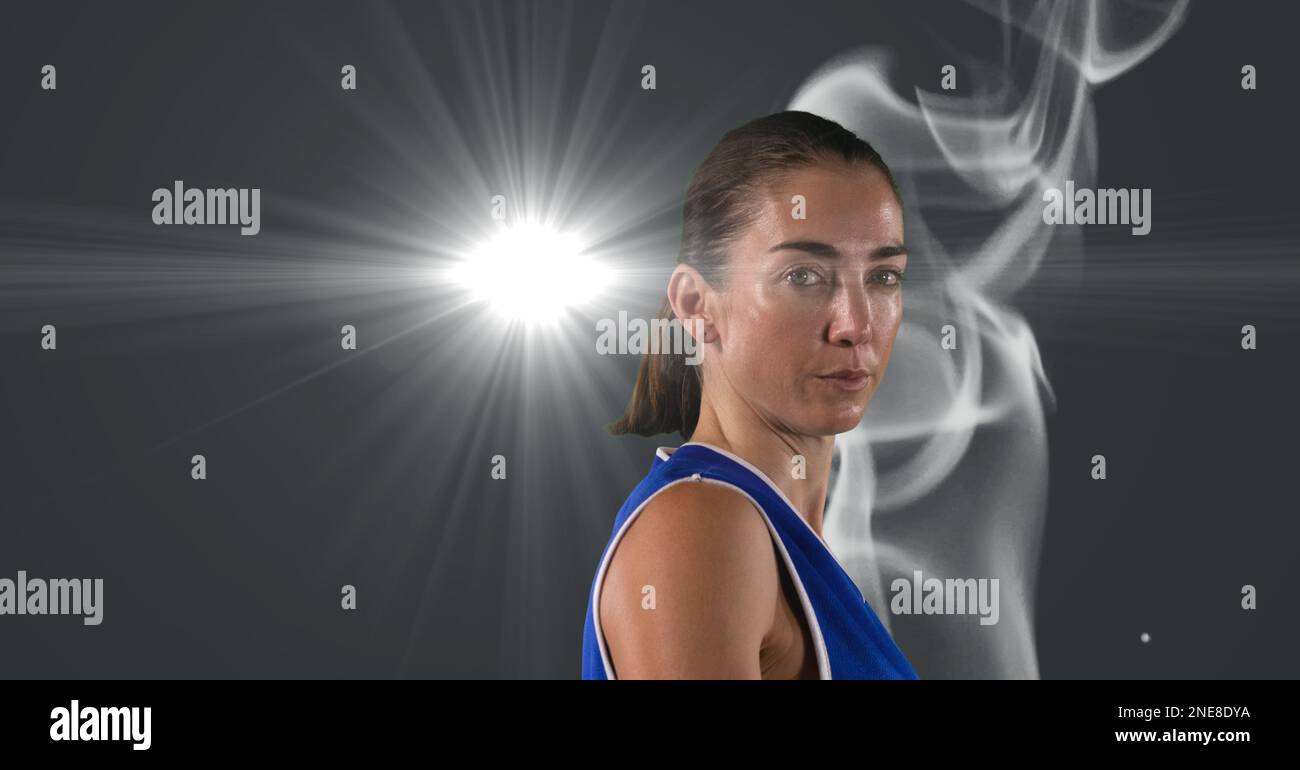 Portrait of caucasian female athlete against smoke effect and light