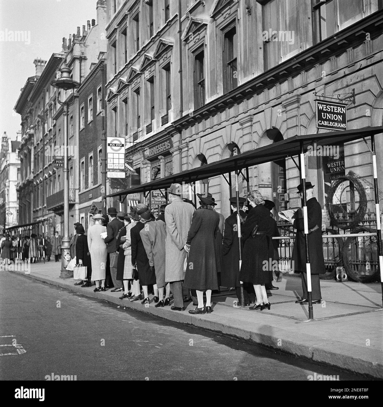 Standing in line for a bus. Passengers can line up only two abreast