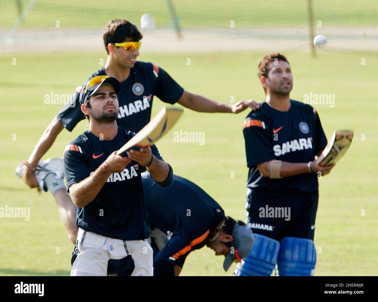 India's Virat Kohli, left, and Sachin Tendulkar, right, bounce the ball