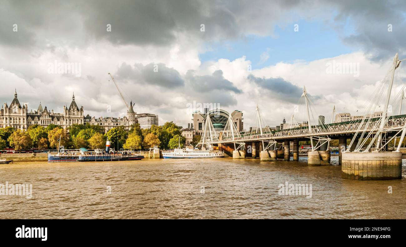 View  of Charing Cross station, the Hungerford Bridge and the Golden Jubilee footbridge. Also  the R.S. Hispaniola and Tattershall Castle. Stock Photo