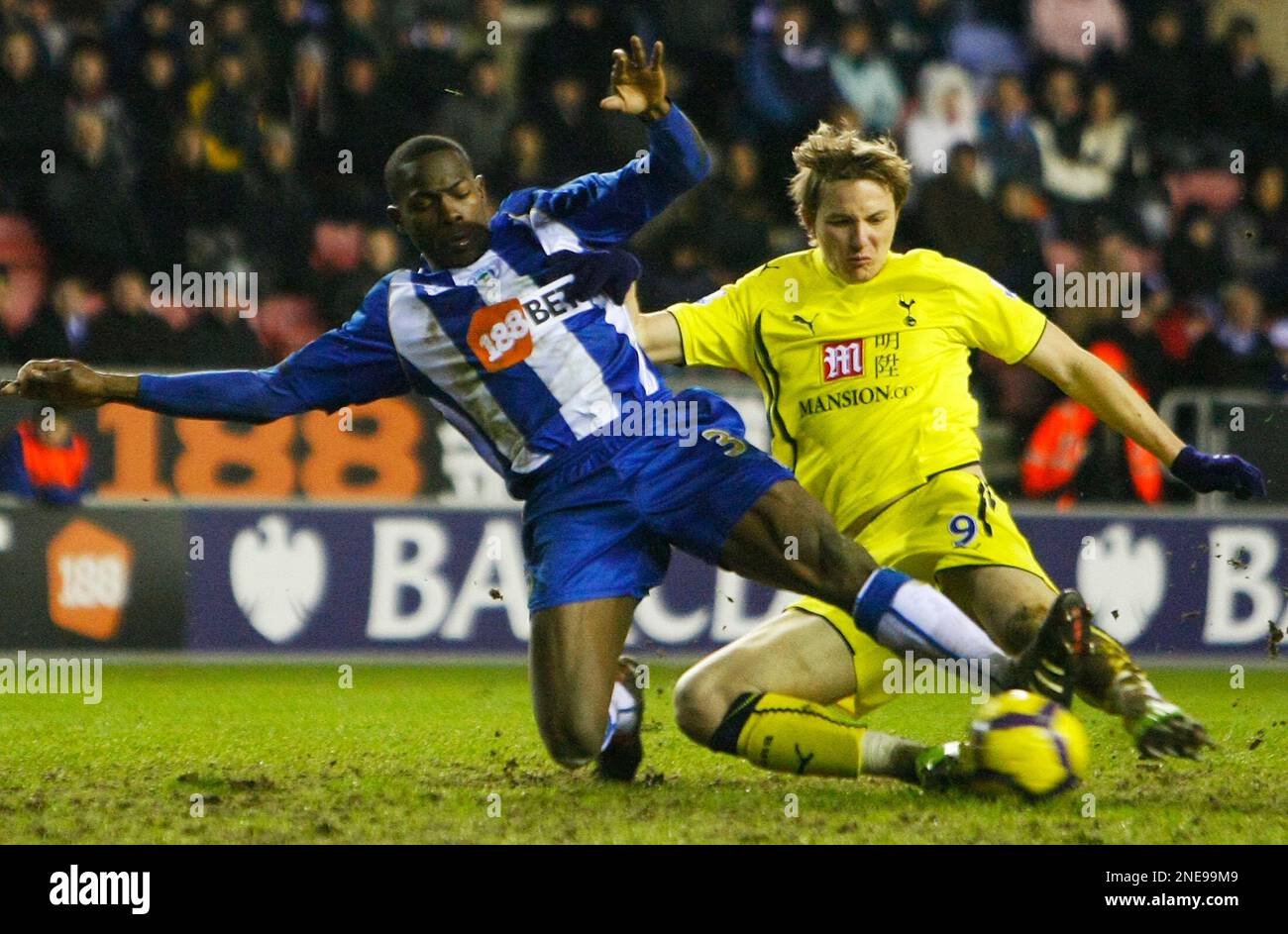 Tottenham Hotspur's Roman Pavlyuchenko, right, beats the tackle of Wigan  Athletic's Maynor Figueroa to score a goal during their English Premier  League soccer match at DW Stadium, Wigan, England, Sunday Feb. 21