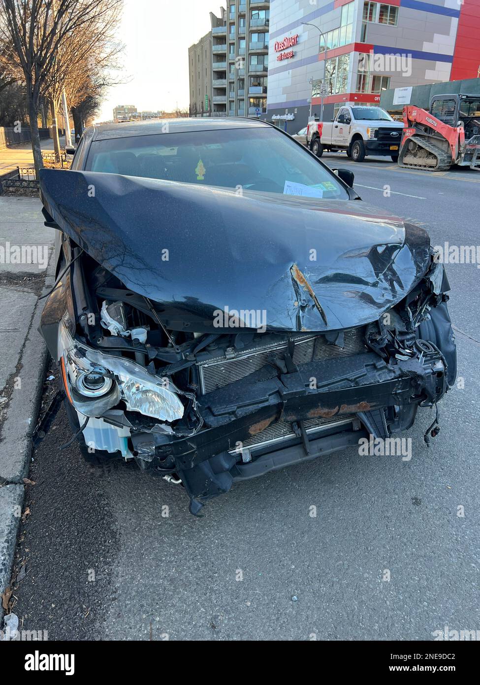 Damaged front end of a car parked on the street after an accident in