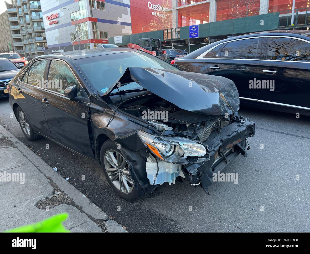 Damaged front end of a car parked on the street after an accident in ...