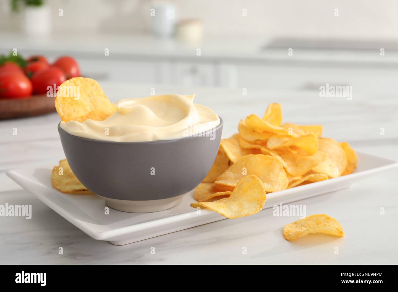 Potato chips and mayonnaise on white marble table Stock Photo - Alamy
