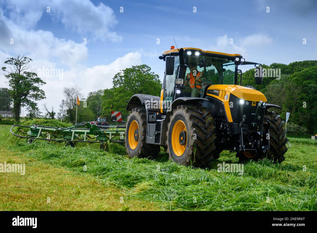 JCB Fastrac spreading out a field of newly mown grass to help dry it