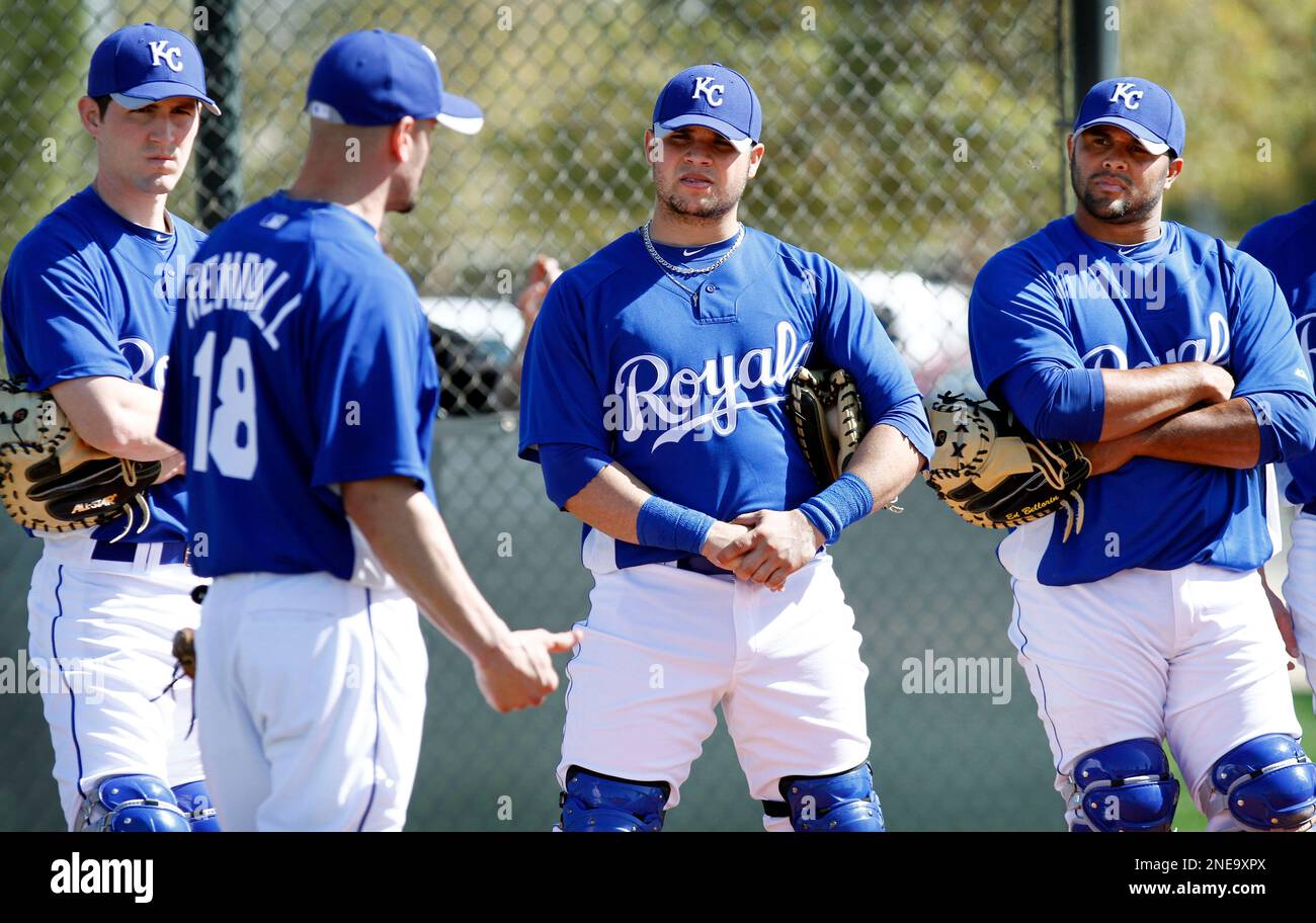 Kansas City Royals catchers Cody Clark, left, Manny Pina and Edwin Bellorin, right, listen to teammate Jason Kendall (18) during a drill on the teams first day of baseball spring training for