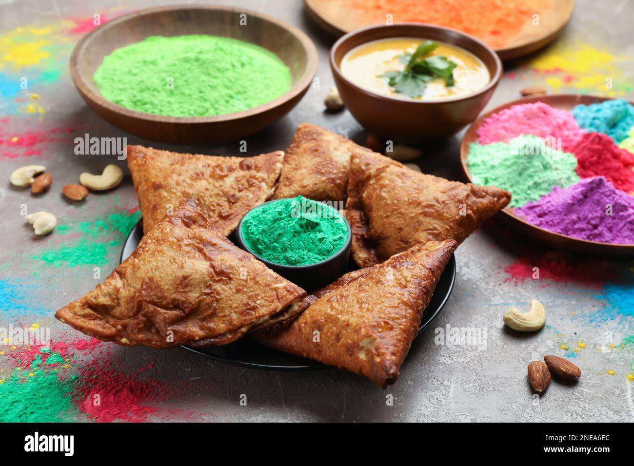 Traditional Indian food and color powders on grey table. Holi festival celebration Stock Photo