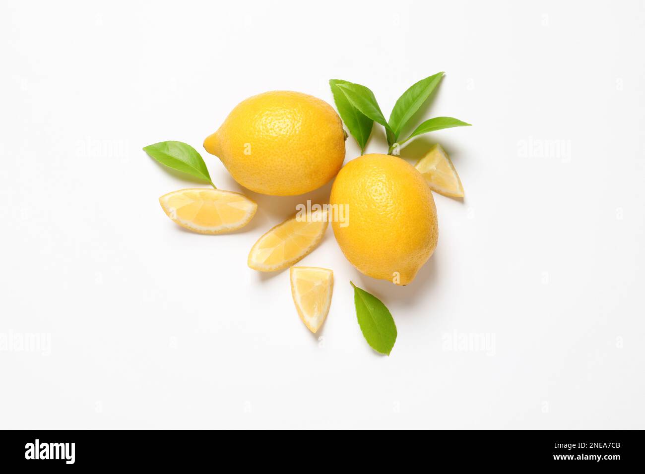 Whole and cut lemons with leaves on white background, top view Stock ...