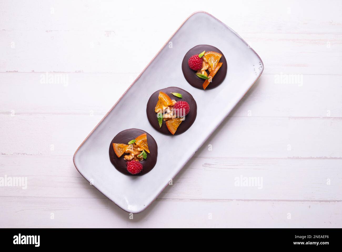 Chocolate dessert with candied orange, raspberry and nuts Stock Photo