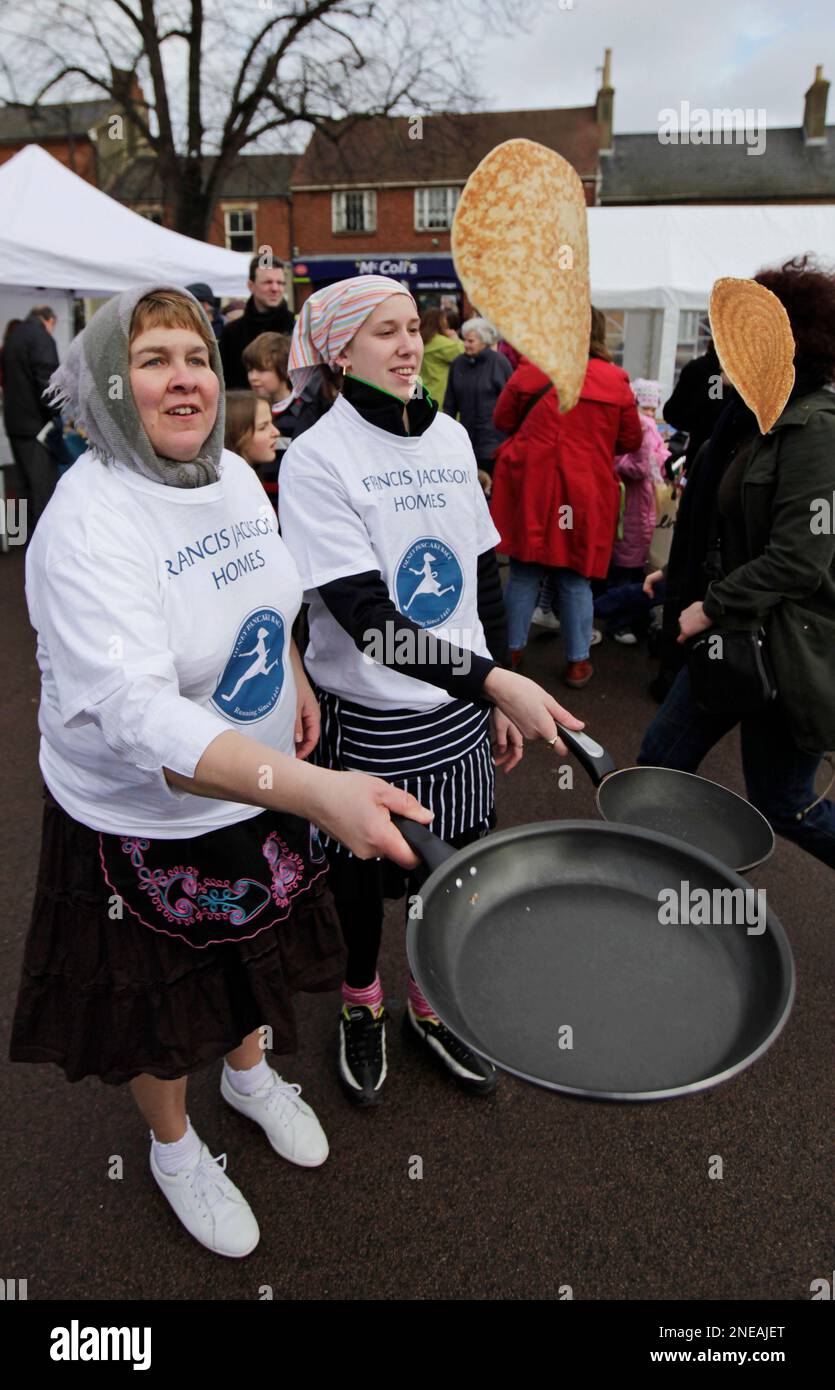 Runners, wearing aprons and caps, flip their pancakes on their frying