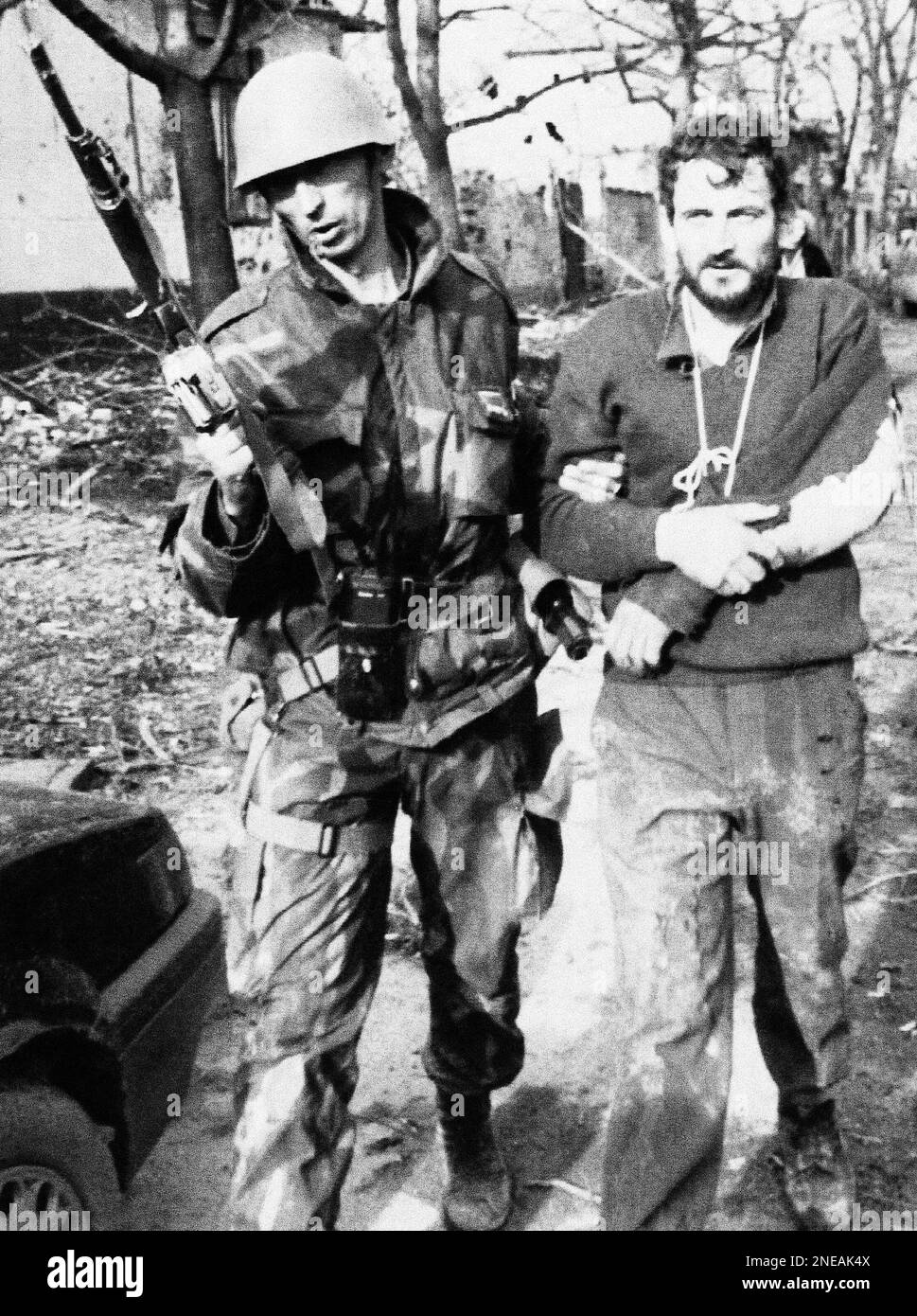 A Yugoslav Federal army soldier leads a captured Croatian guardsman on ...