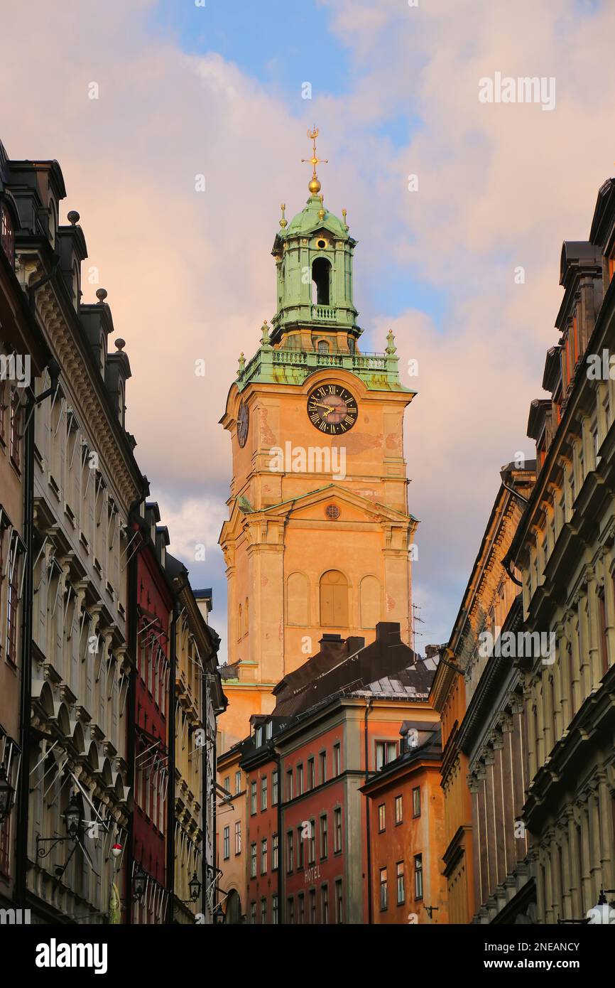 Clock tower of the Church of St Nicholas, behind a historic street of