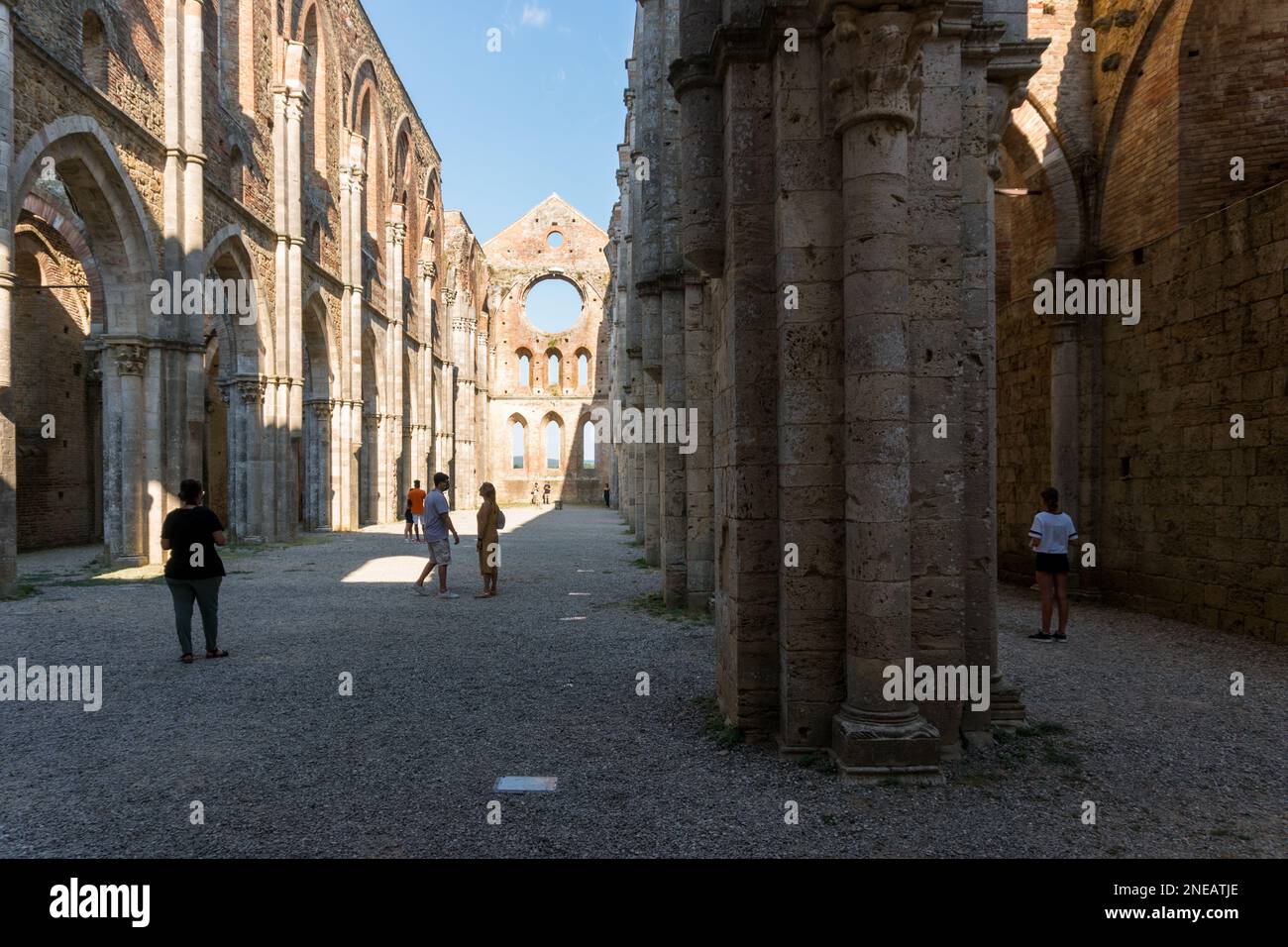 San Galgano ,Italy-august 8,2020:Tourists visit the interior of the abbey and former monastery of San Galgano famous for being roofless during a sunny Stock Photo