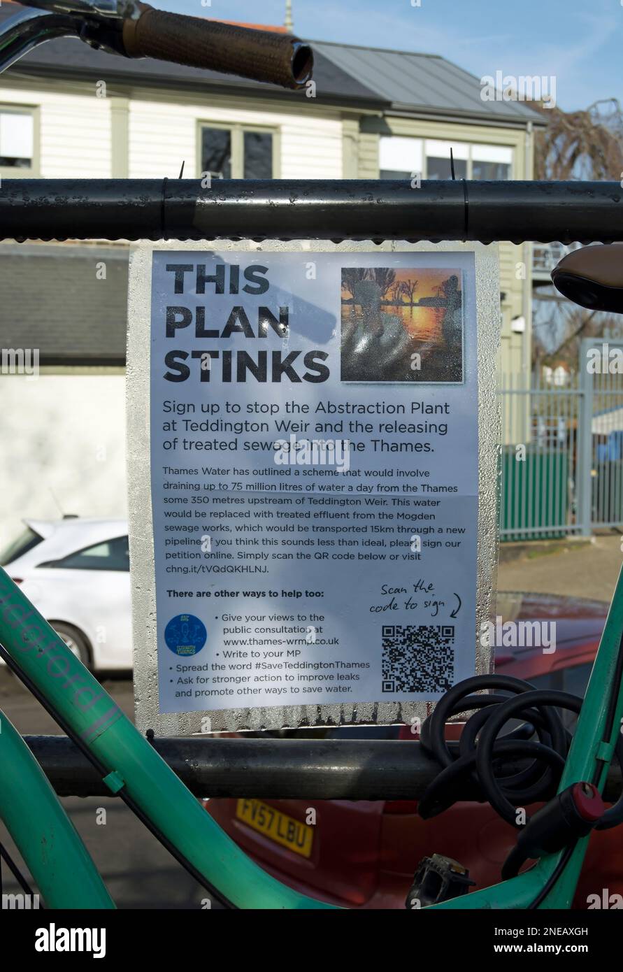 seen through a bicycle frame, a notice posted by opponents of a 2023 scheme to release treated sewage into the river thames at teddington weir Stock Photo