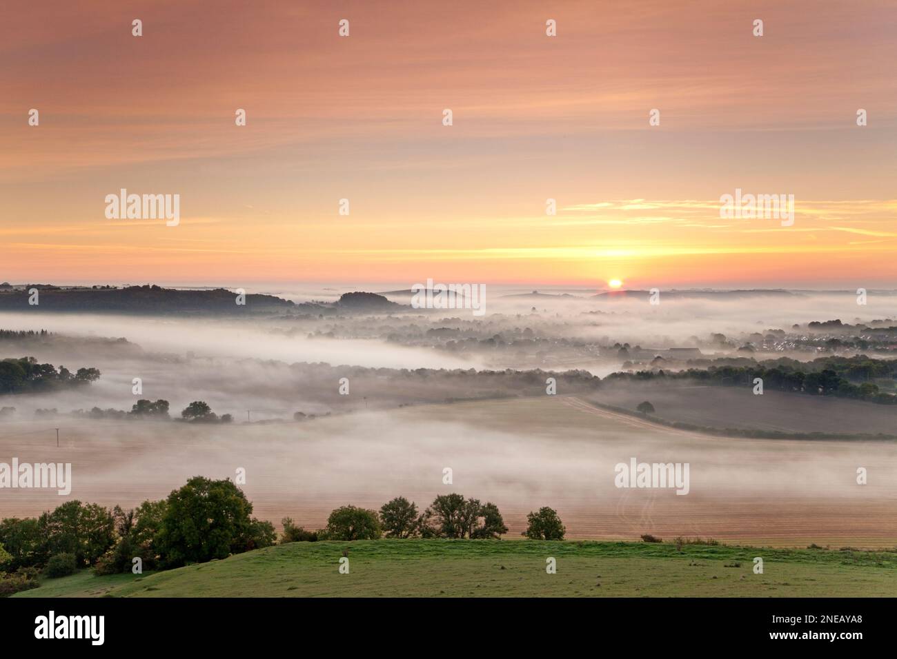 A misty sunrise over Warminster in Wiltshire, photographed from Cley Hill. Stock Photo