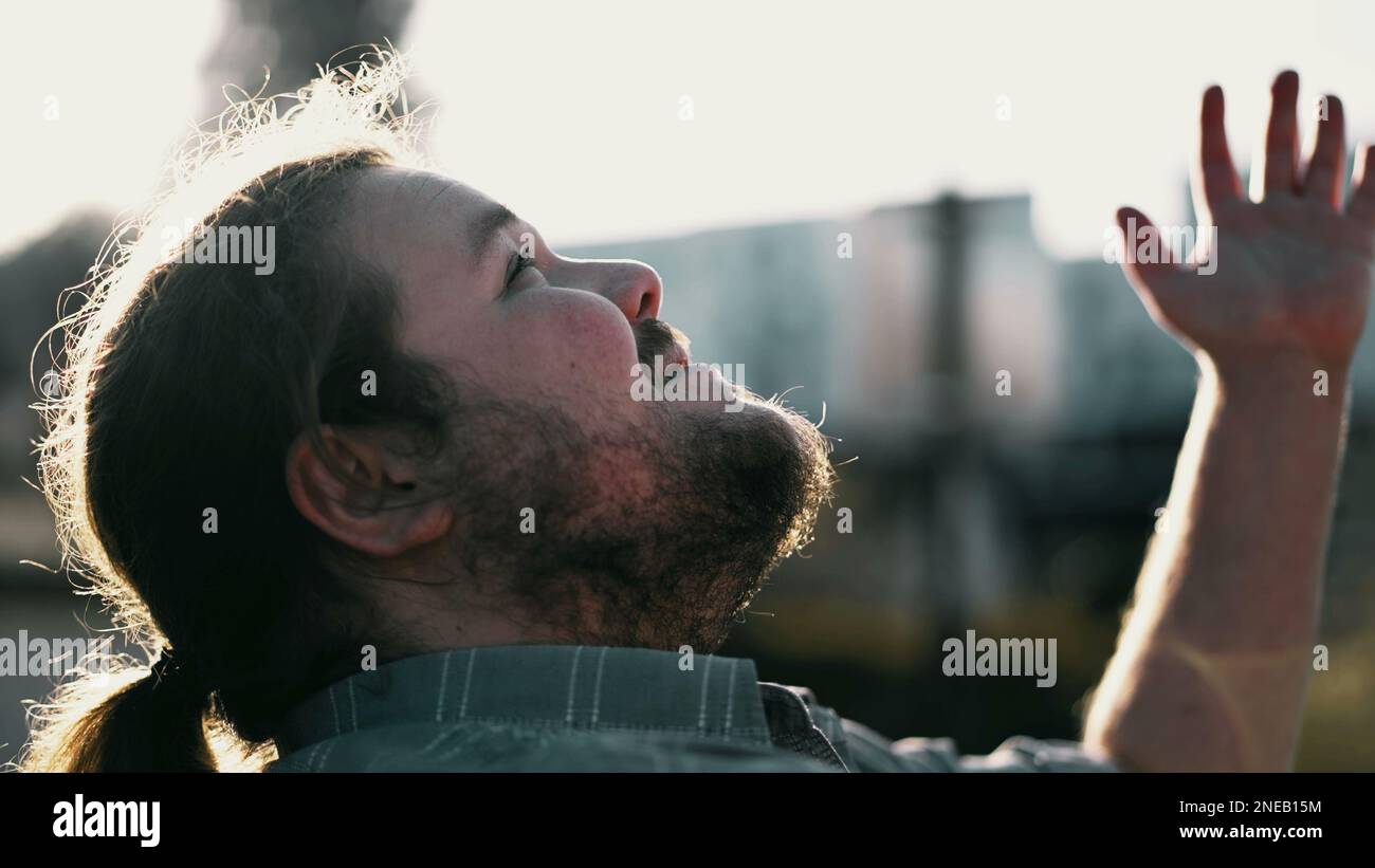 One faithful overweight guy standing outdoors in prayer. Grateful male