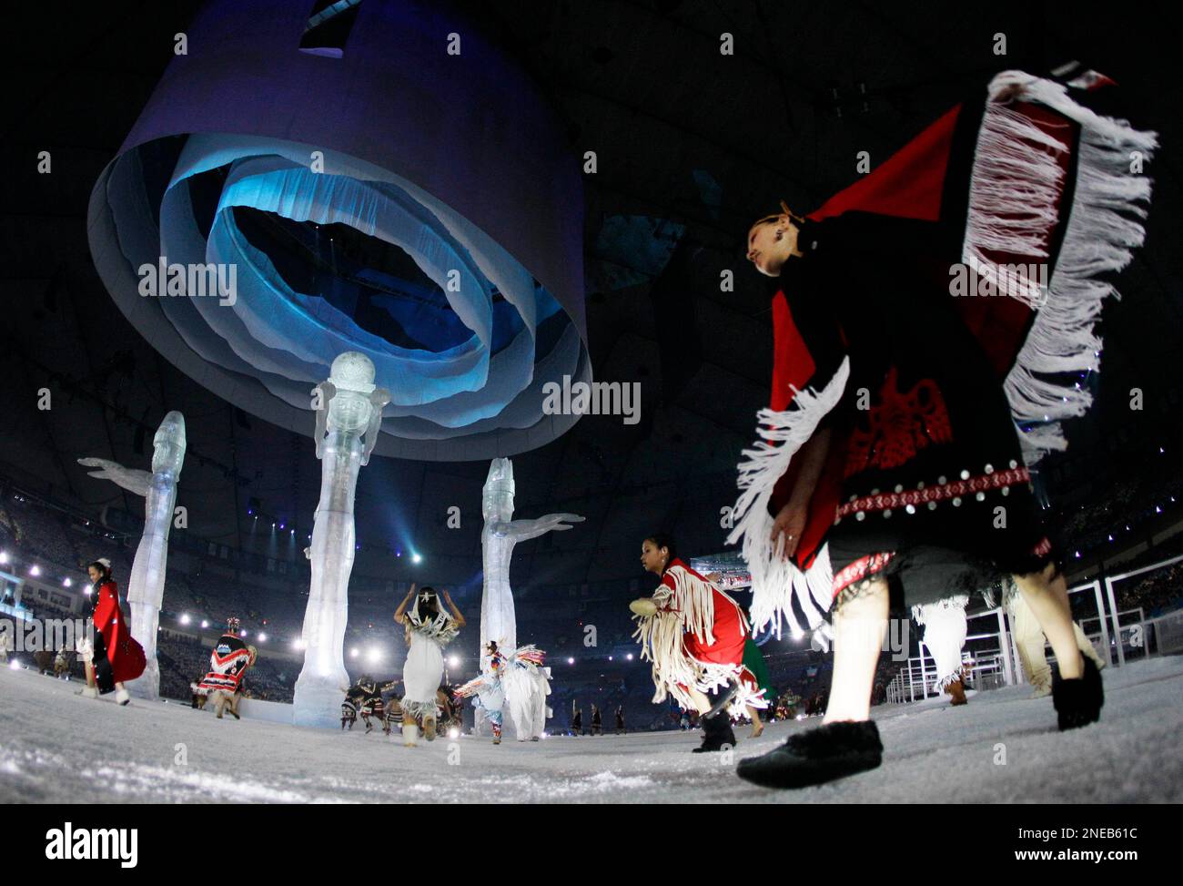 Aboriginal people of Canada dance around Poles during the opening ceremony for the