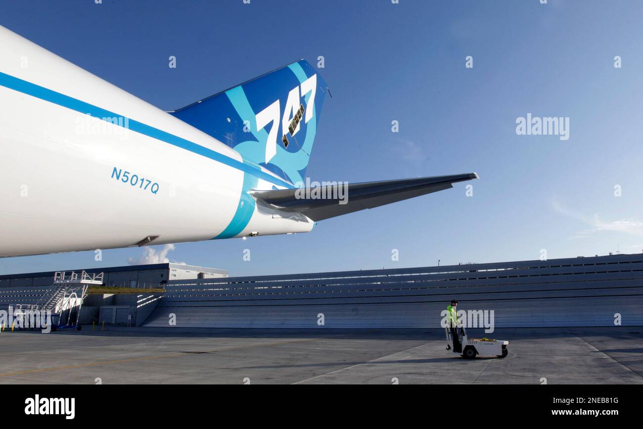 A ramp worker is dwarfed by the tail of Boeing Co. 747-8 Freighter ...