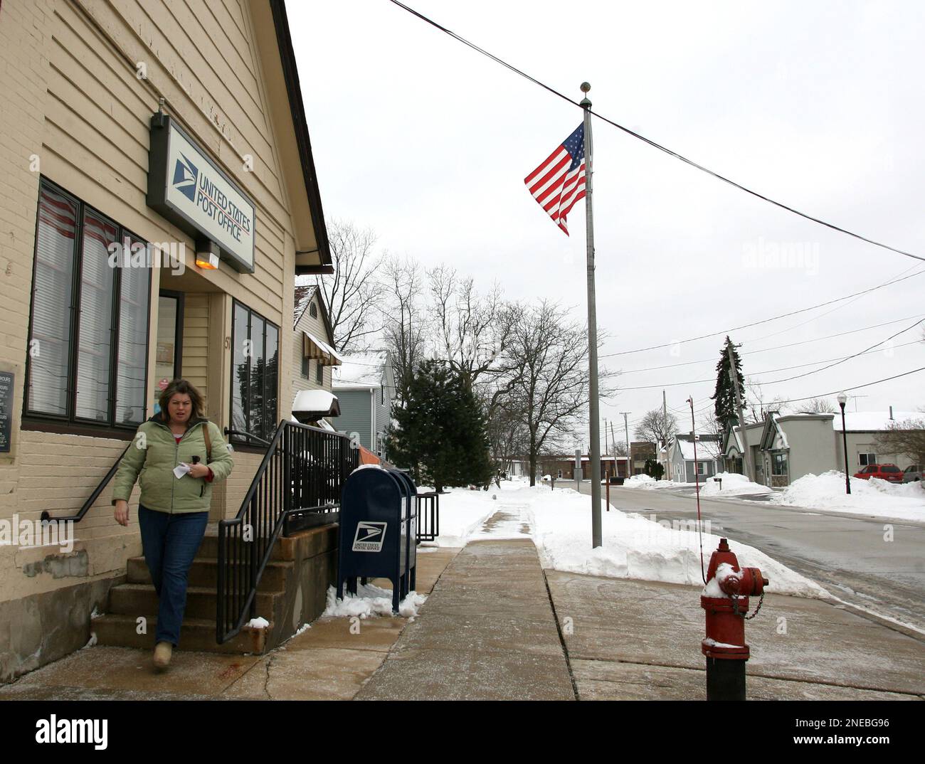 Kim Burkett, of Gilberts, Ill, walks out of the Gilberts Post Office on