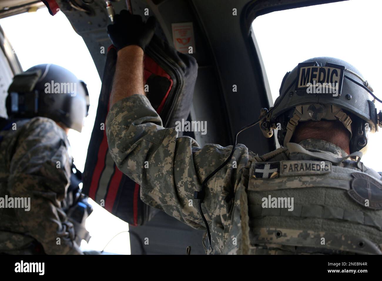 A U.S. Army flight medic looks through the window of a Black Hawk ...