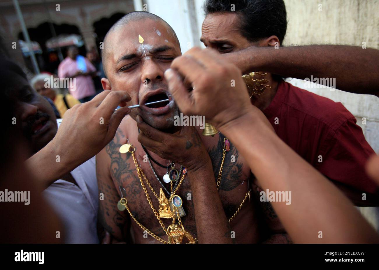 In this photo taken Jan. 30, 2010, a Hindu devotee gets a piercing ...