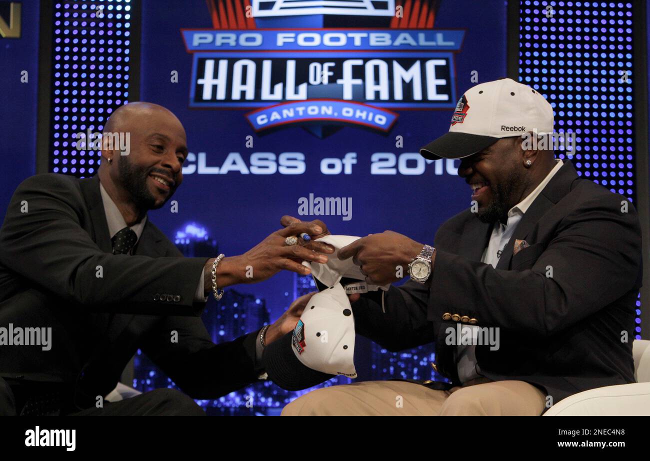 Emmitt Smith, right, autographs hats for Jerry Rice, left, and