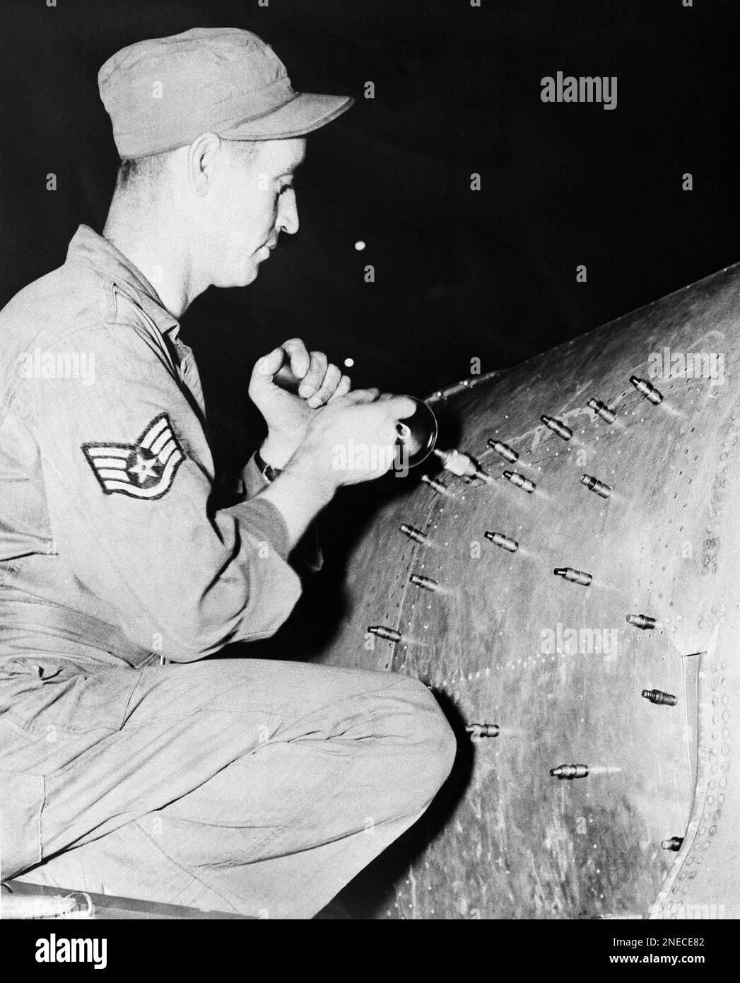 S/Sgt. Carba V. Avey, of Bluffs, Ill., rivets a new panel on a F-80 jet ...