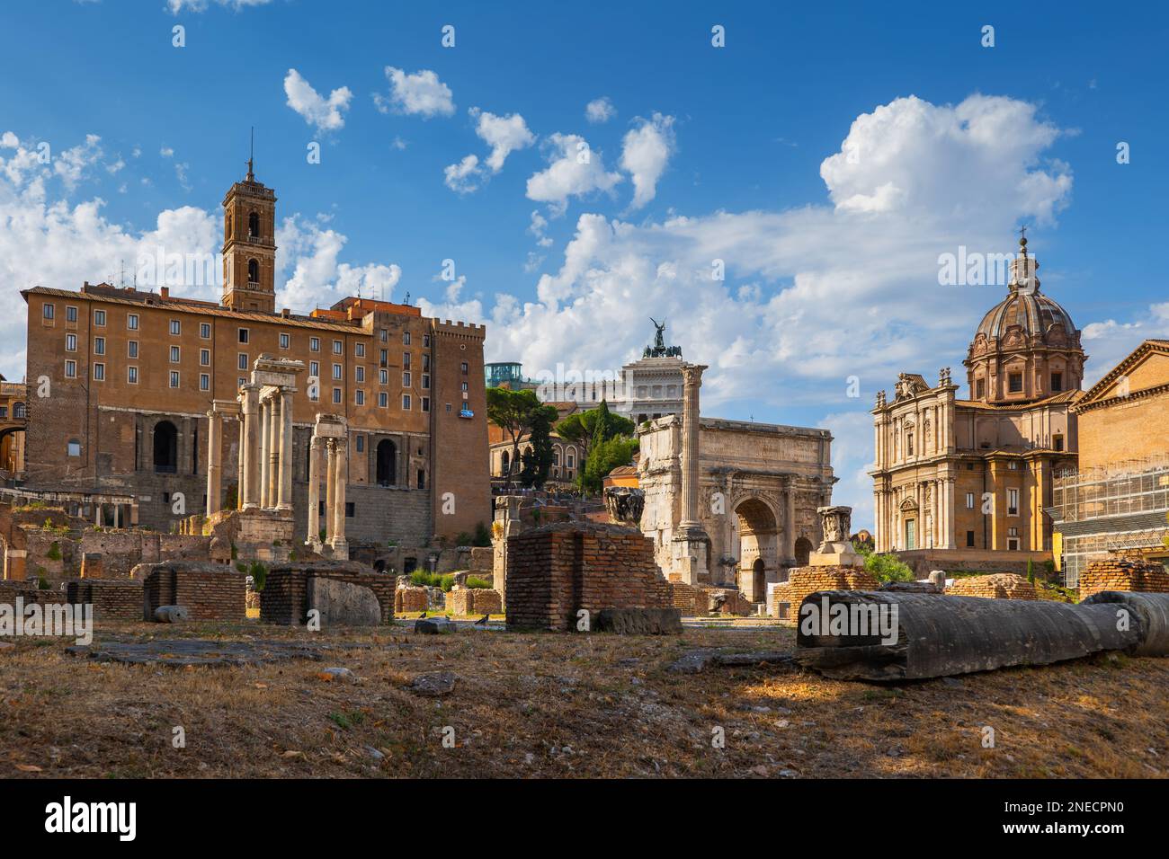 The Roman Forum at sunset in Rome, Italy. Skyline featuring Tabularium, Temple of Saturn, Temple of Vespasian and Titus, Arch of Septimius Severus and Stock Photo