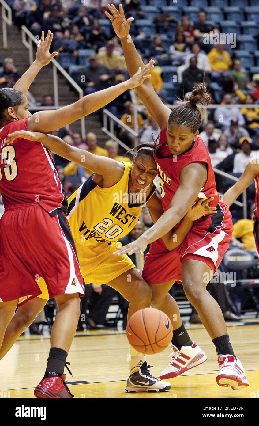 West Virginia's Asya Bussie (20) is defended by Louisville's Monique Reid,  left, and Keshia Hines, right, in the second half of an NCAA college  basketball game in Morgantown, W.Va. on Saturday, Jan.