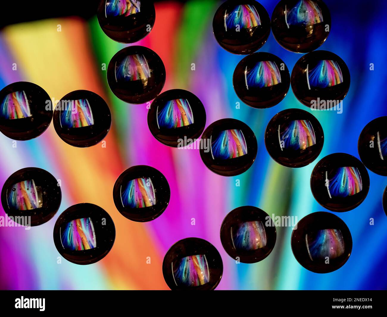 Colorful abstract pattern reflecting in black ringed glass drops Stock Photo