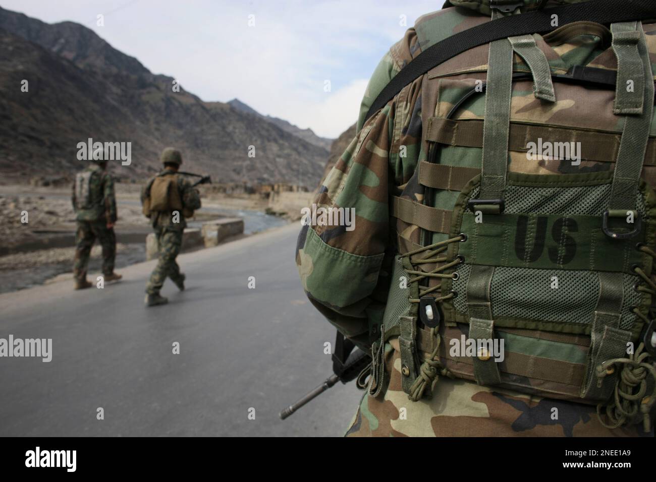 Afghan National Army soldiers, right, and far left, walk with their U.S