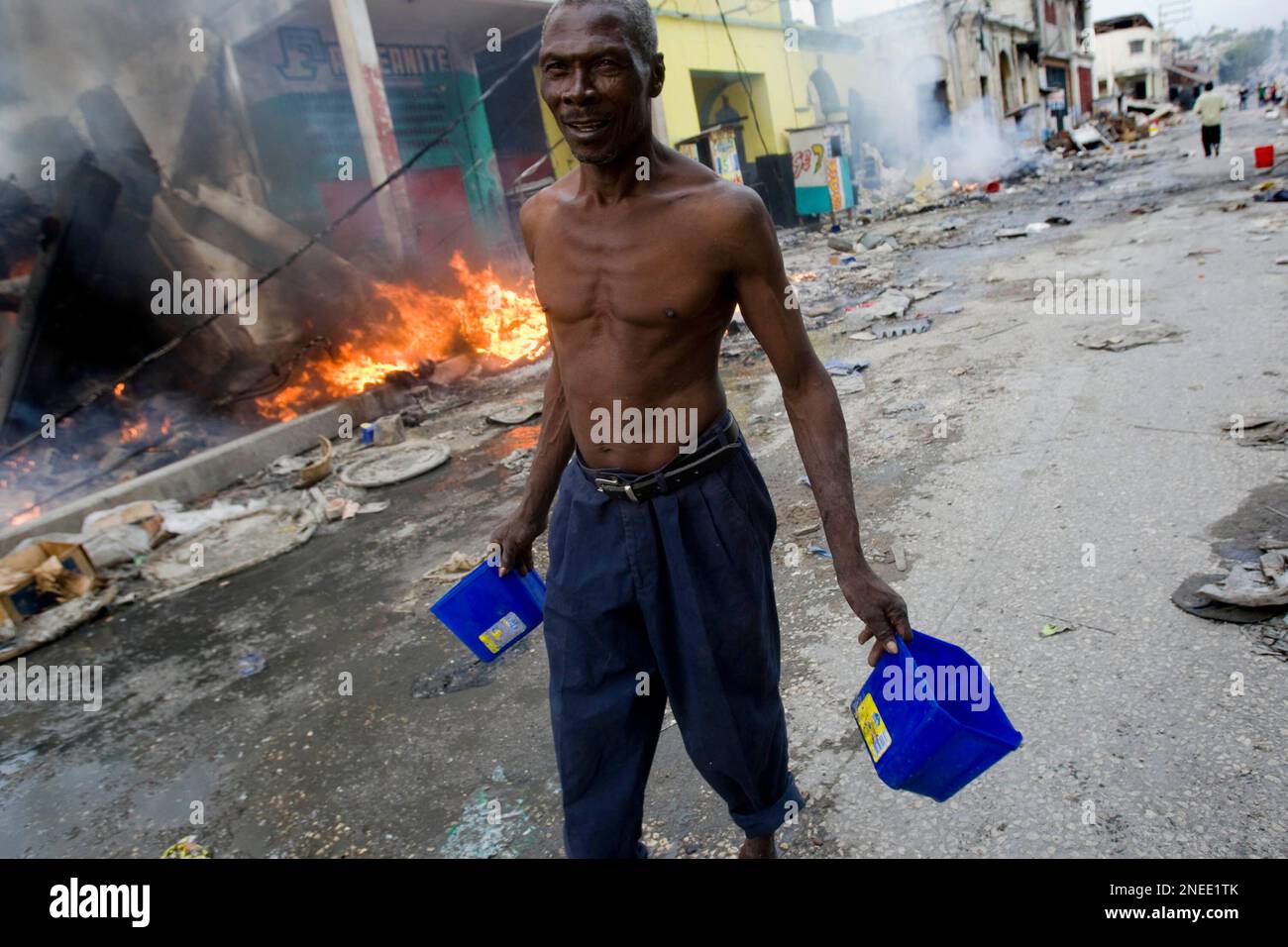 A man throw water on a fire in downtown Port au Prince. Port au Prince