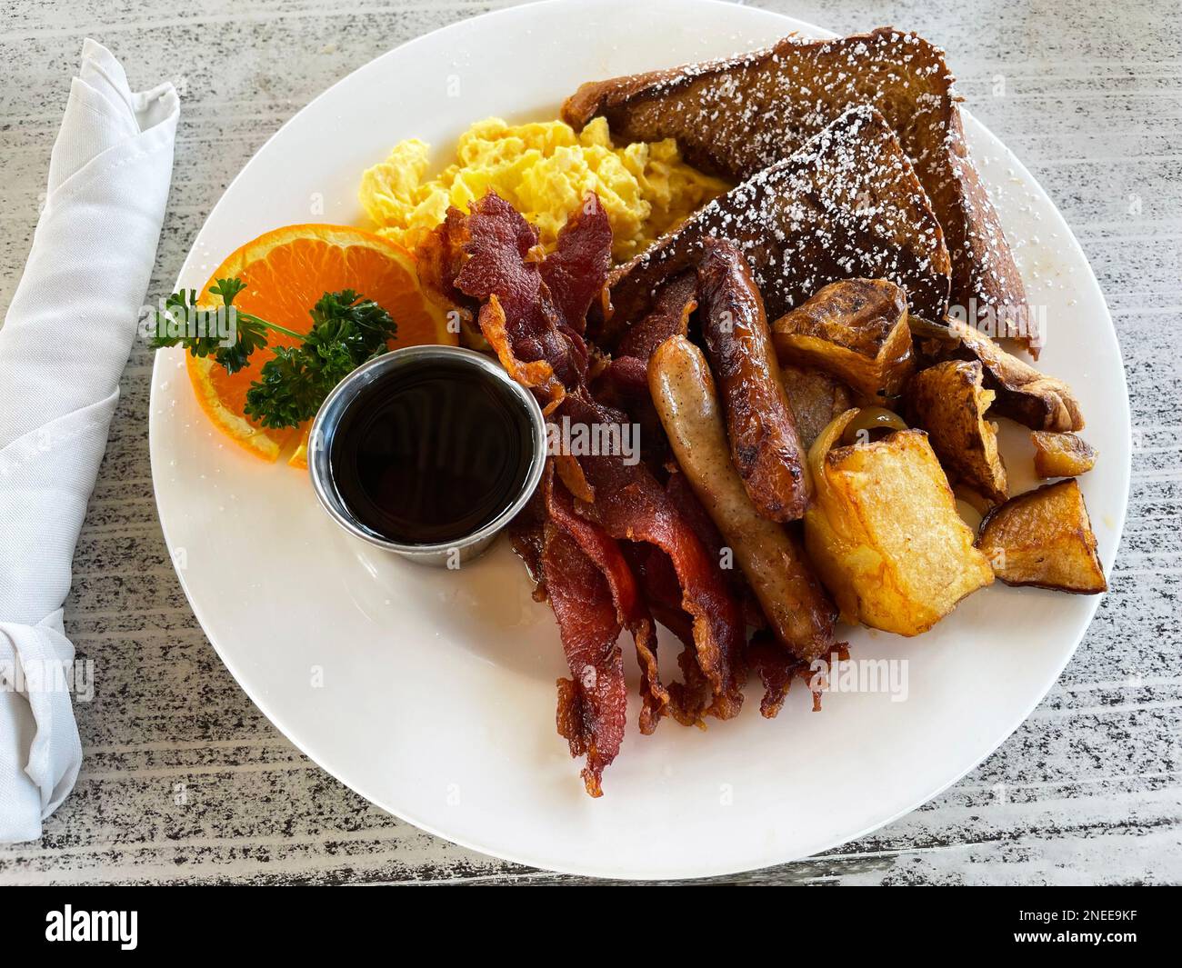 Closeup of a large plate of breakfast with scrambled eggs, bacon