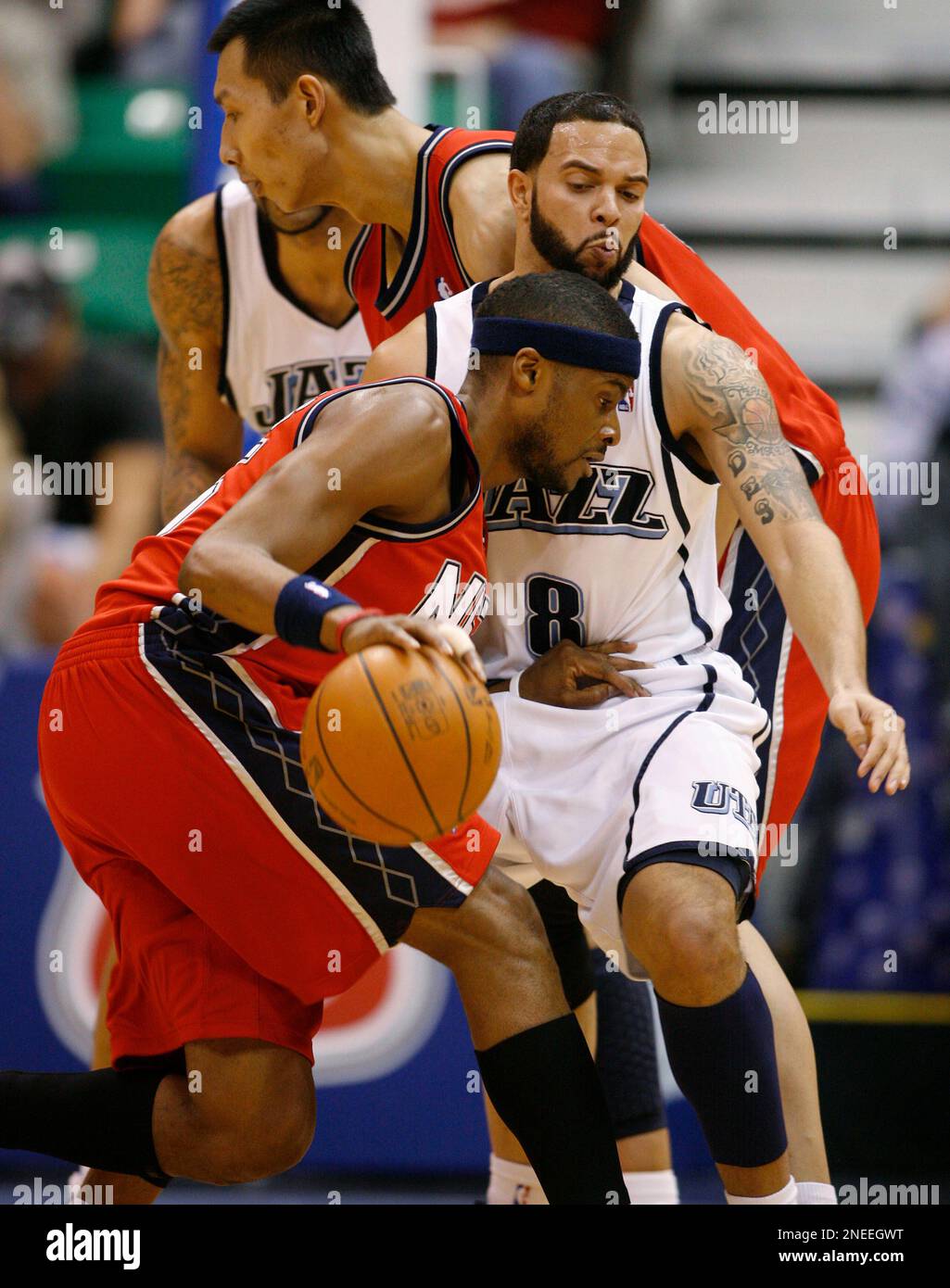 New Jersey Nets guard Keyon Dooling, left, drives around Utah Jazz guard Deron  Williams, right, on a screen set by New Jersey Nets forward Yi Jianlian, of  China, rear, during the first