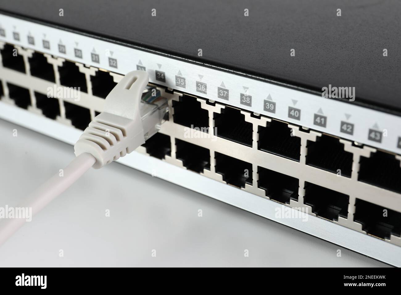 Closeup view of network switch with cable on light background. Internet ...