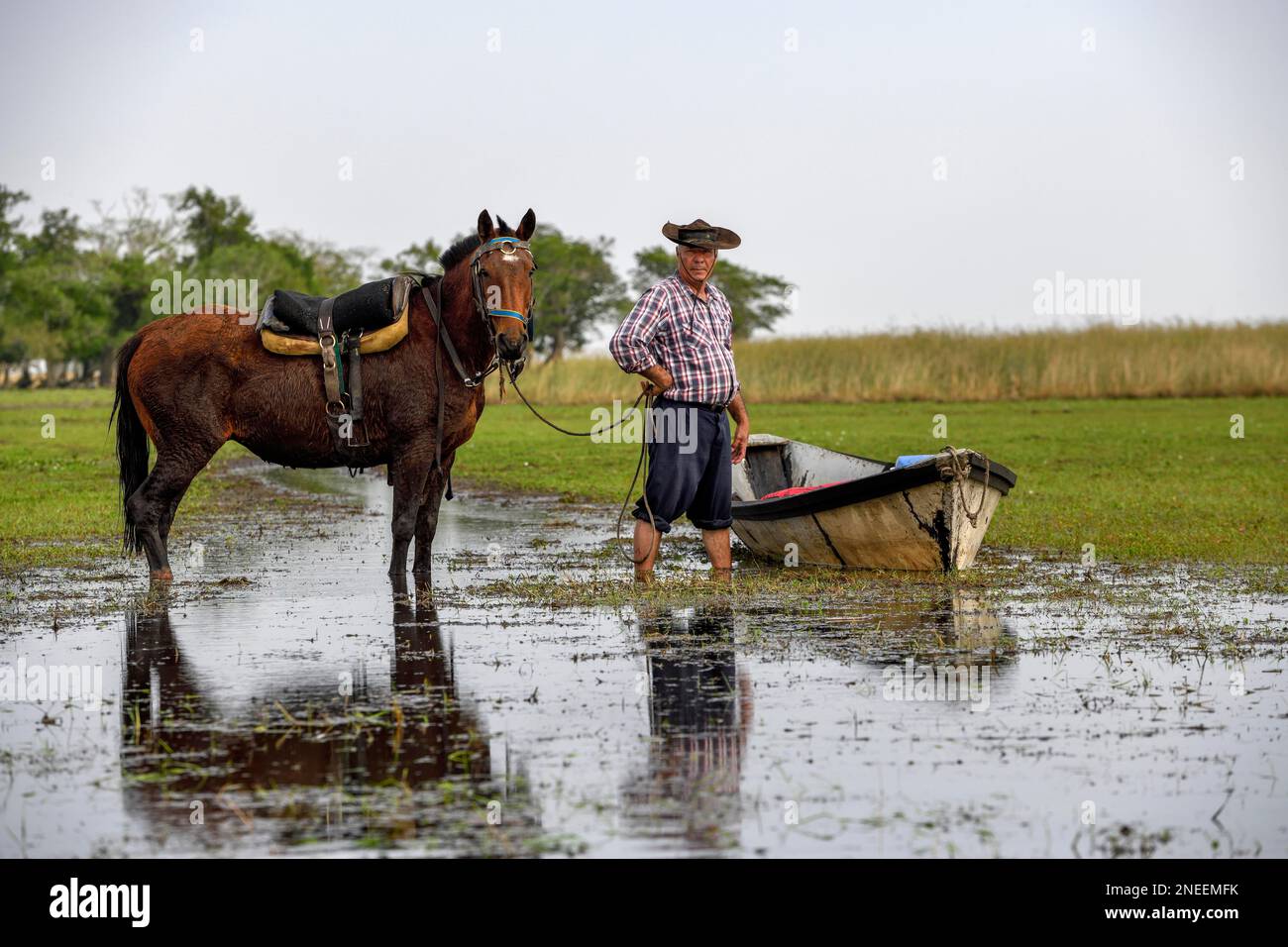 Gaucho with horse and boat at Puesto Mingo, Esteros del Ibera, near Concepcion del Yaguarete Cora, Corrientes Province, Argentina Stock Photo