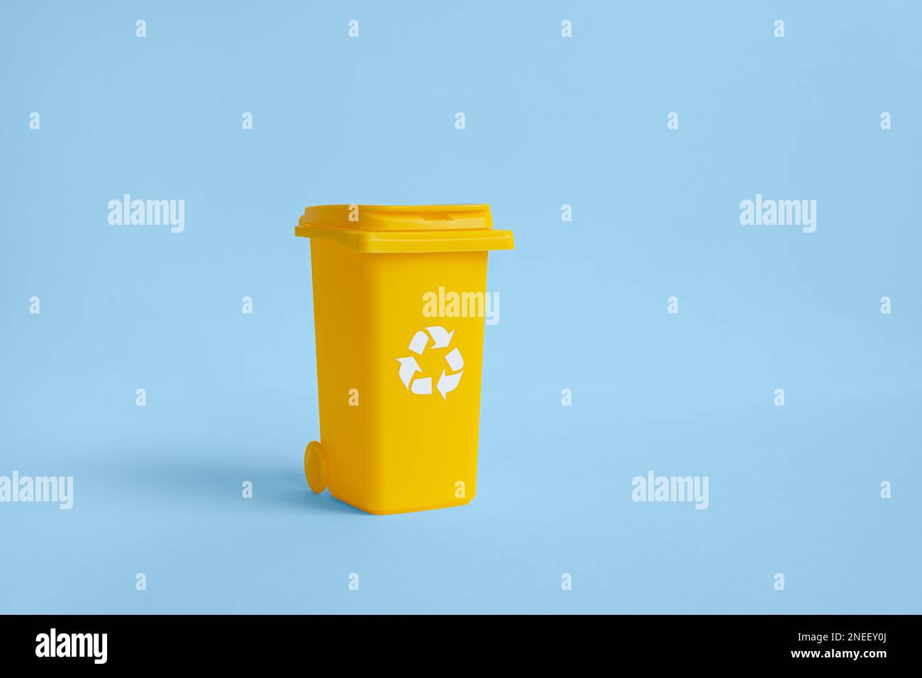 Yellow container for paper garbage collection, isolated on the blue