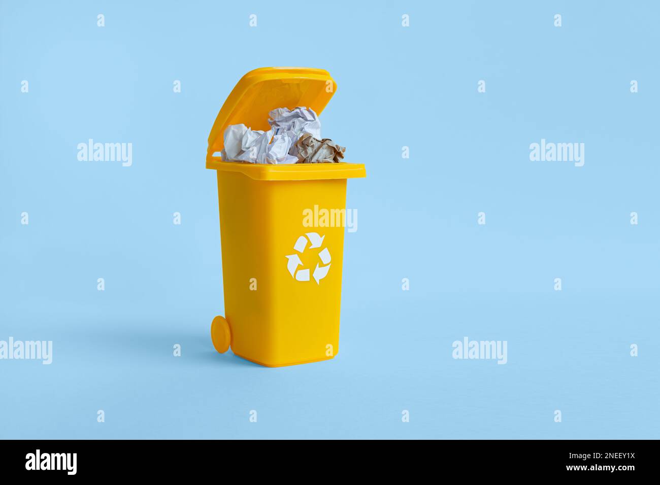 Almost closed container with paper waste isolated on the blue background with copy space, waste recycling concept Stock Photo