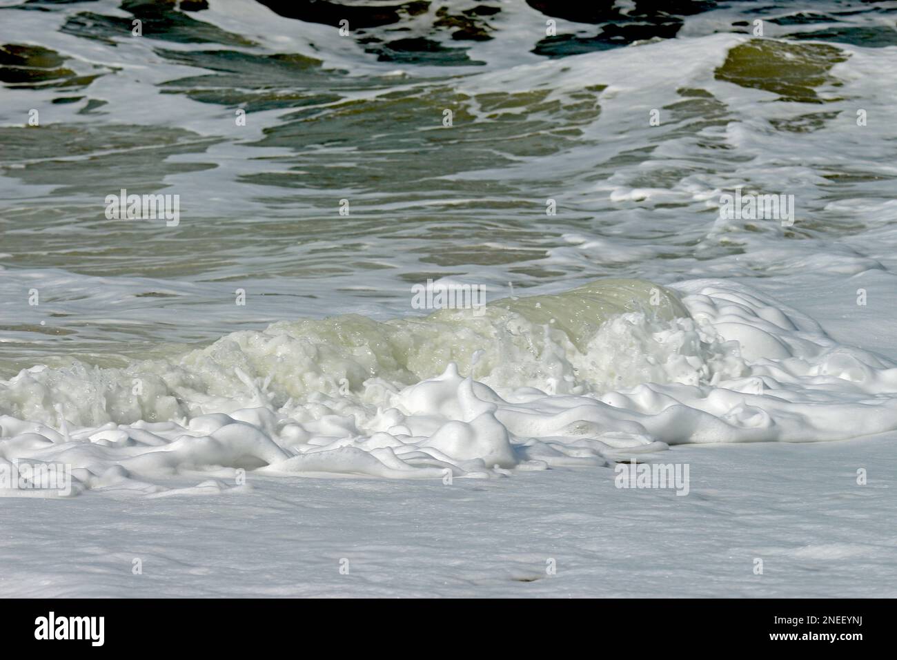 The waves when they hit the sand on the beach. The foam that paints abstract and beautiful images. It's nature in all its forms.. Stock Photo