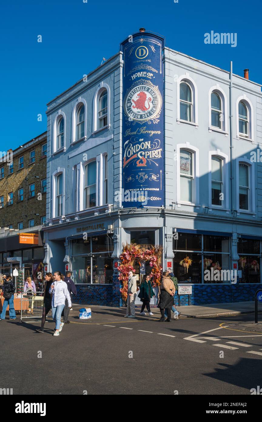 People out and about on a sunny day, Portobello Road. Colourful facade of The Distillery hotel