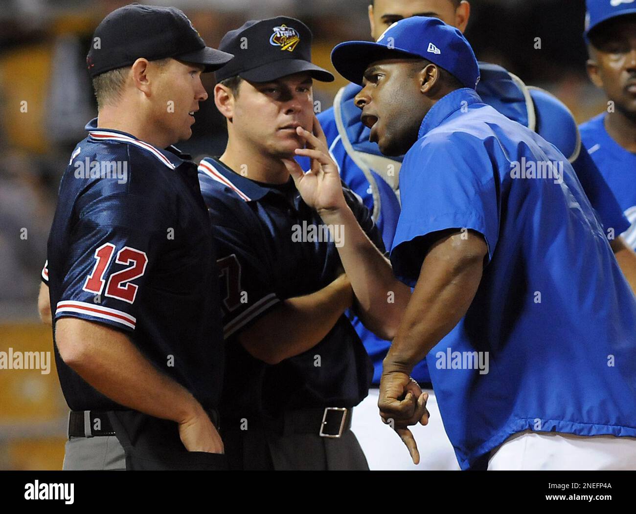 Jose Offerman, right, manager of the Dominican Republic winter league team Licey Tigers, argues with plate umpire Jason Bradley and first base umpire Daniel Rayburn, center, during a playoff series game against Cibao Giants in Santo Domingo, Saturday, Jan. 16, 2010. Offerman, a former major league All-Star, threw a punch at Rayburn during the argument, the second time in two and a half years that he's attacked someone on a baseball field. (AP Photo/Victor Calvo) Stock Photo