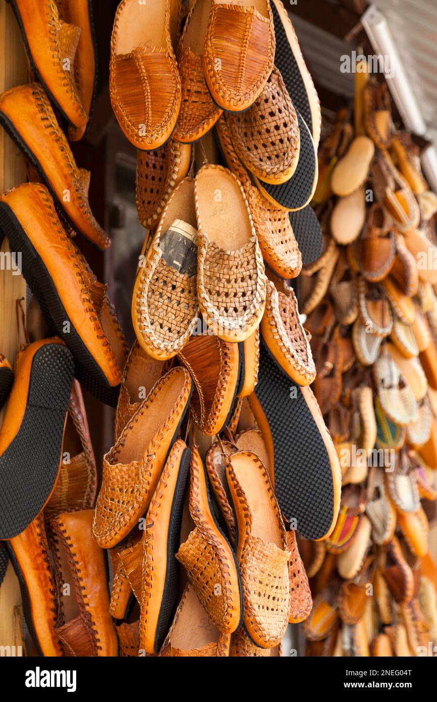 Stack of Opanci for sale on a market stall on Skopje, North Macedonia. Opanci are traditional peasant shoes worn in Southeastern Europe (specifically Stock Photo