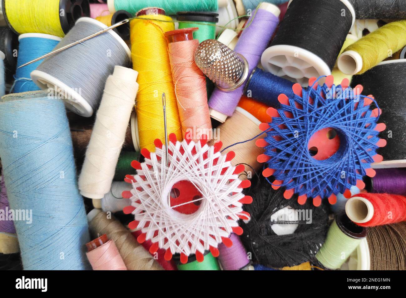 Close-up on a sewing kit (thread, sewing needle and thimble). Stock Photo