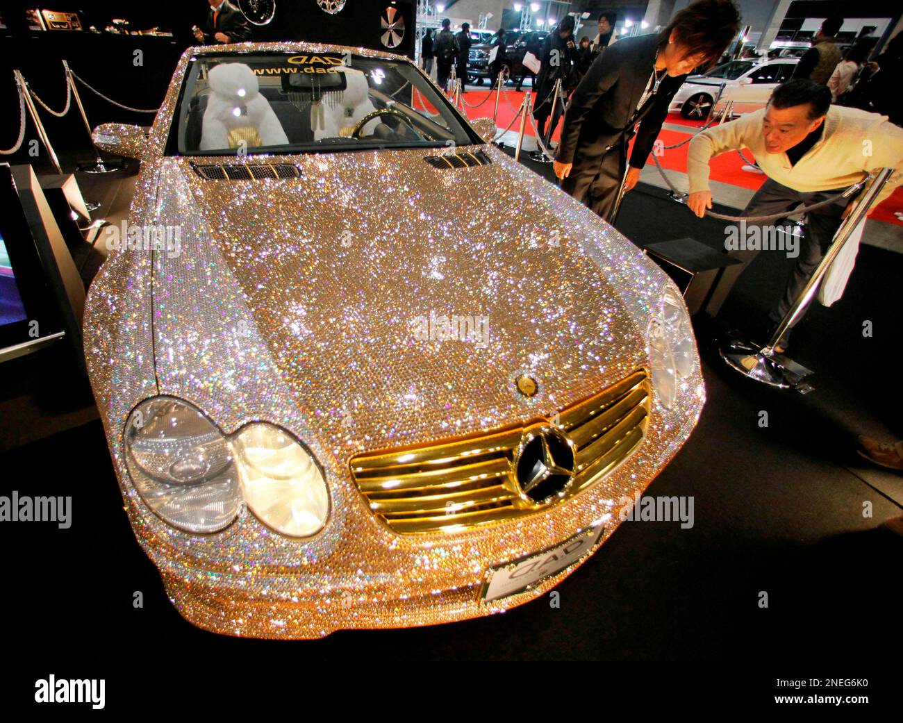 Visitors look at a Mercedes-Benz SL-600 covered by Swarovski's