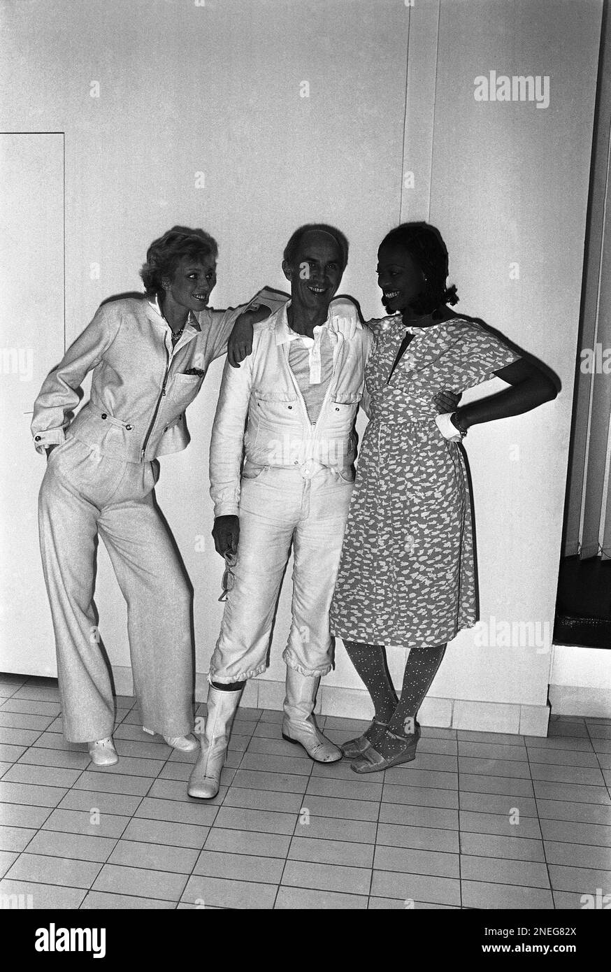 Paris fashion designer Courreges (center) with two of the models he is  presenting in his new Spring-Summer collection. At left English mannequin  Kim wears a trouser suit in pink tweed with zipped