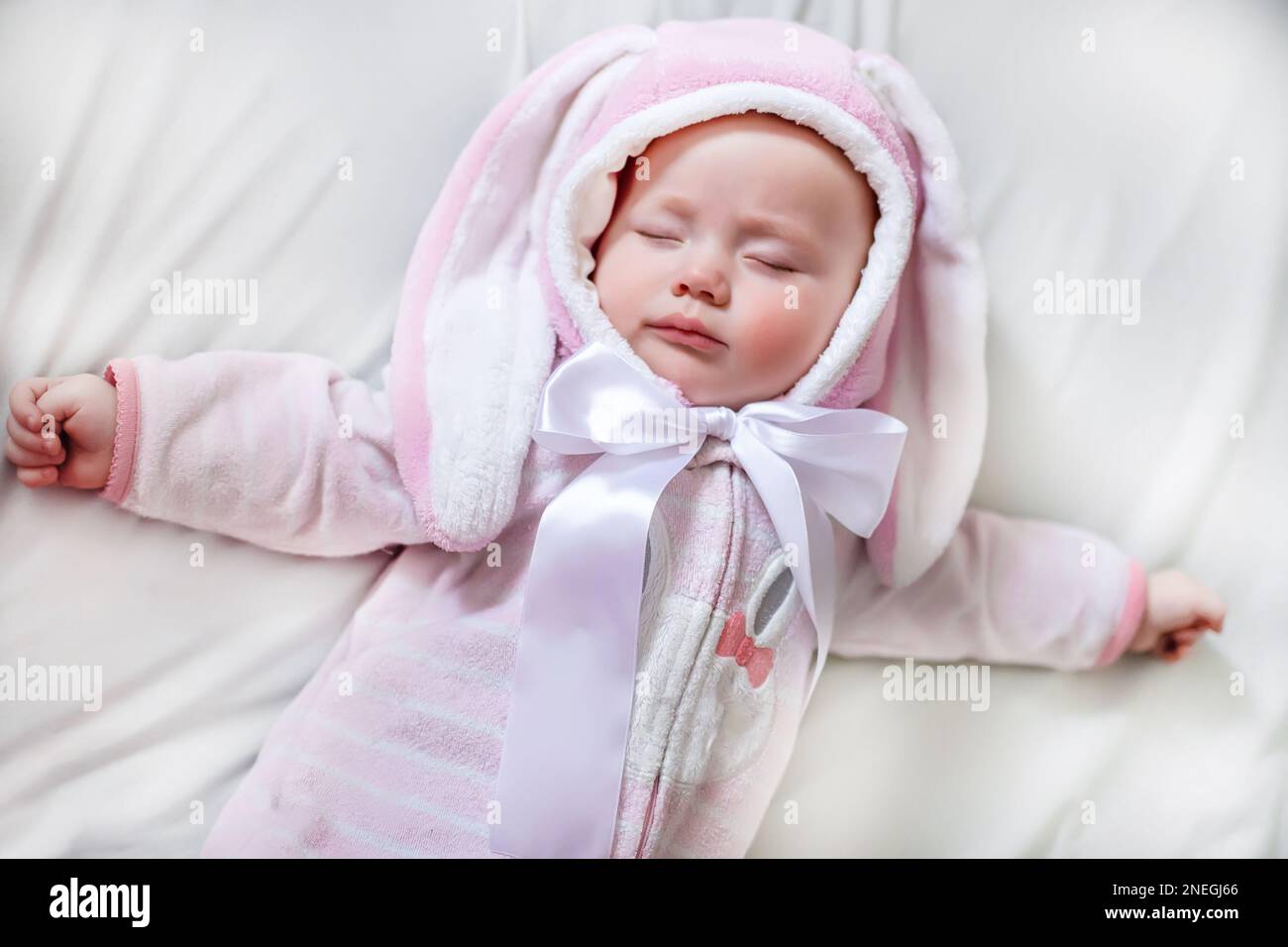 Baby newborn in a sleeping suit with the ears of an Easter bunny rests