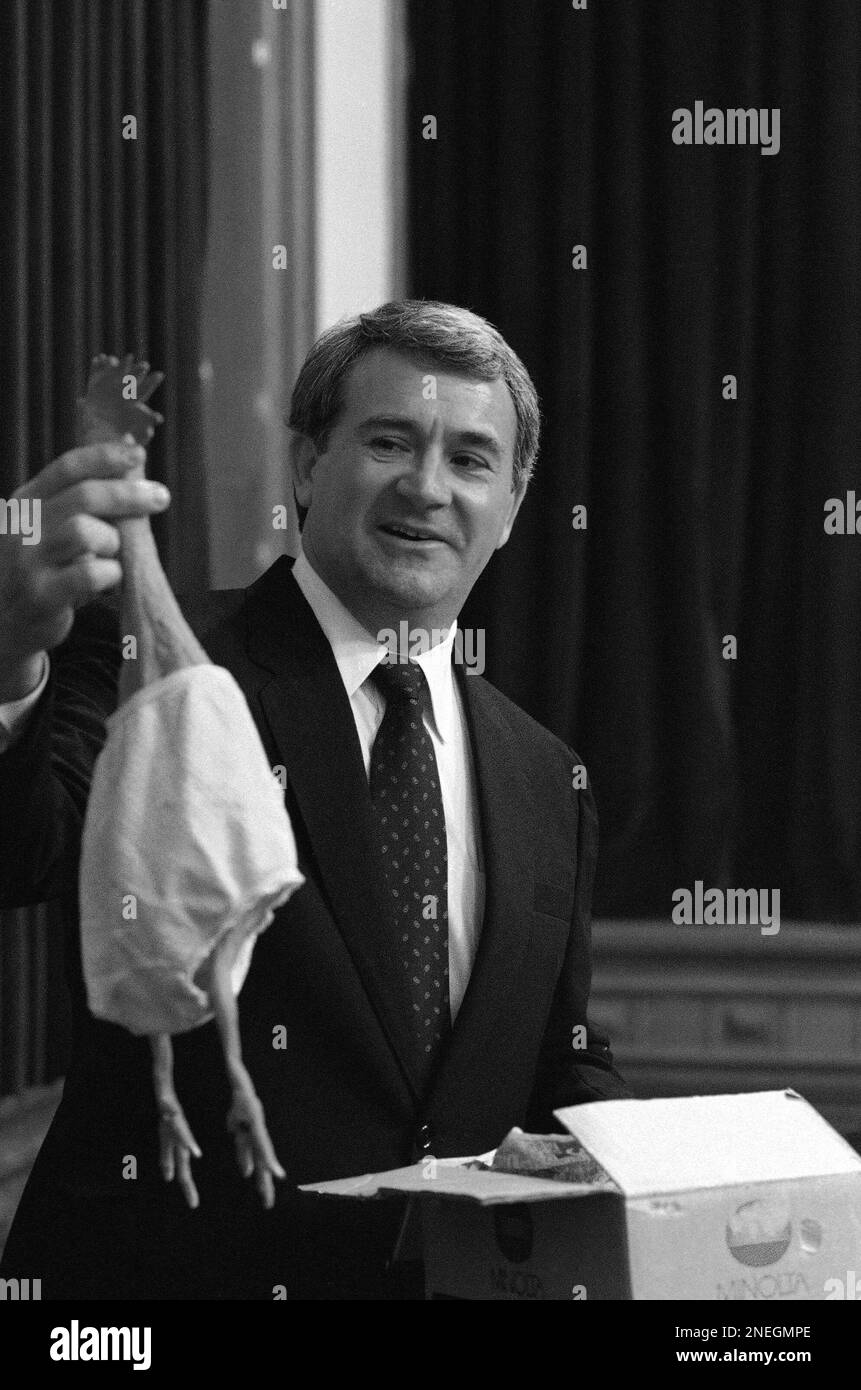 Texas Attorney General Jim Mattox holds up a rubber chicken he received