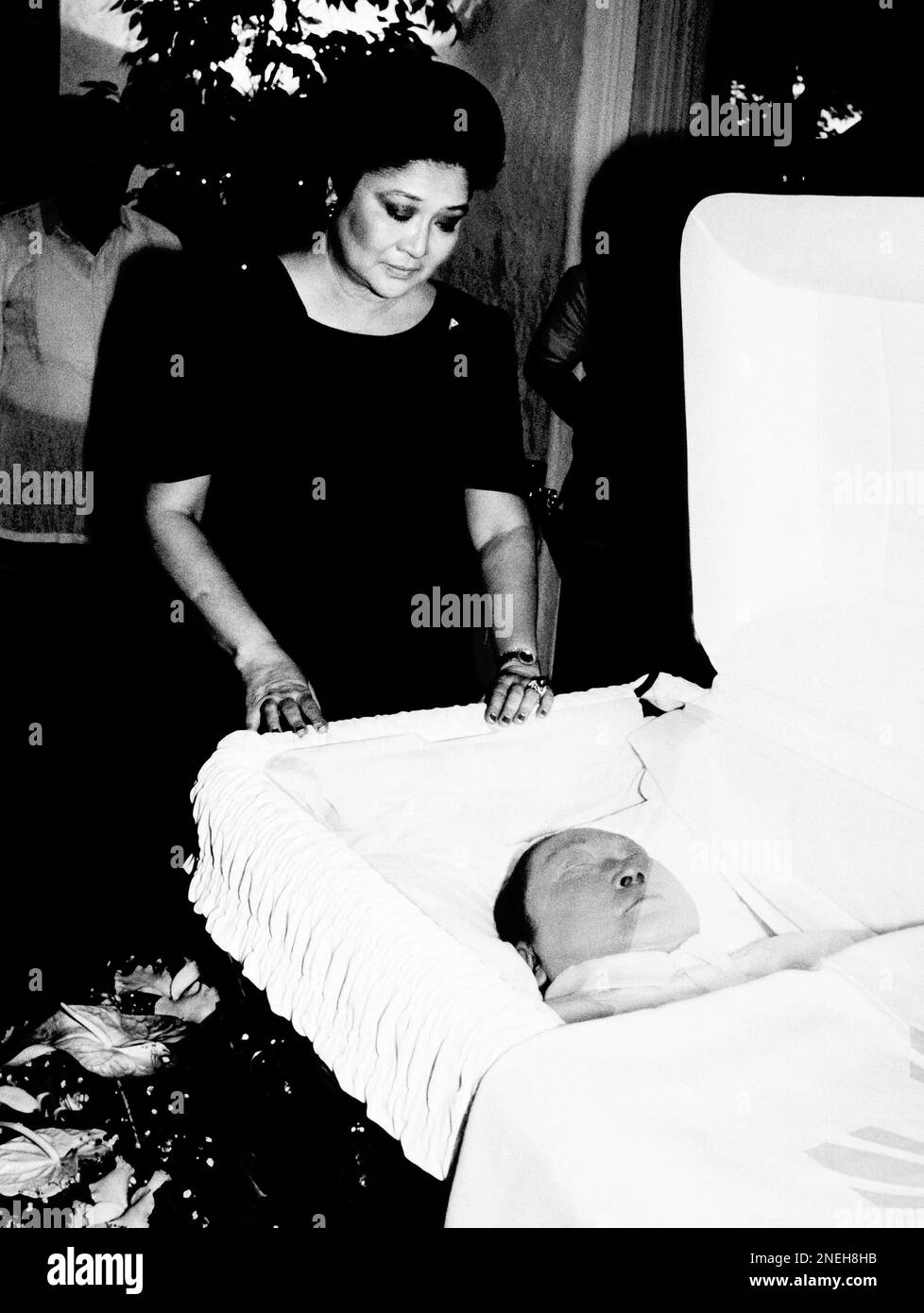 Imelda Marcos touches the casket containing the body of her late